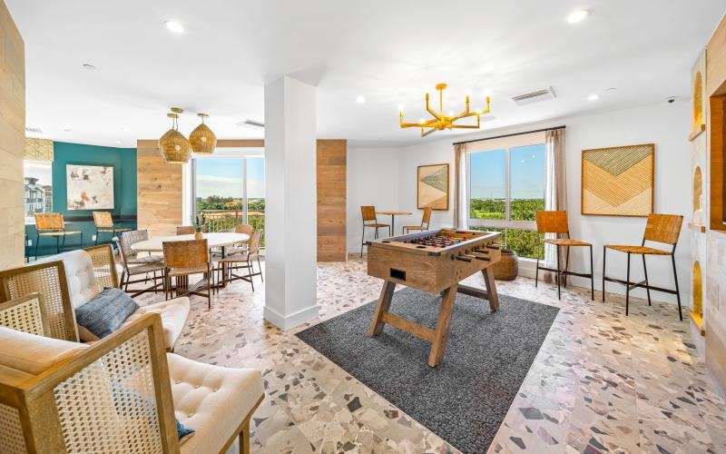 a gameroom with a table chairs and a rug