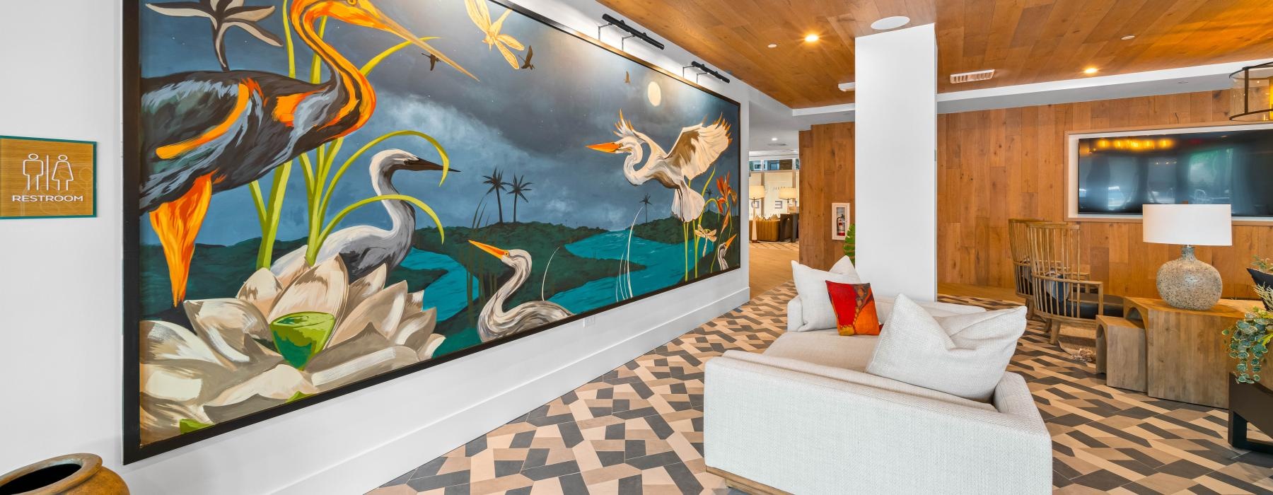 a room with a couch and a painting on the wall